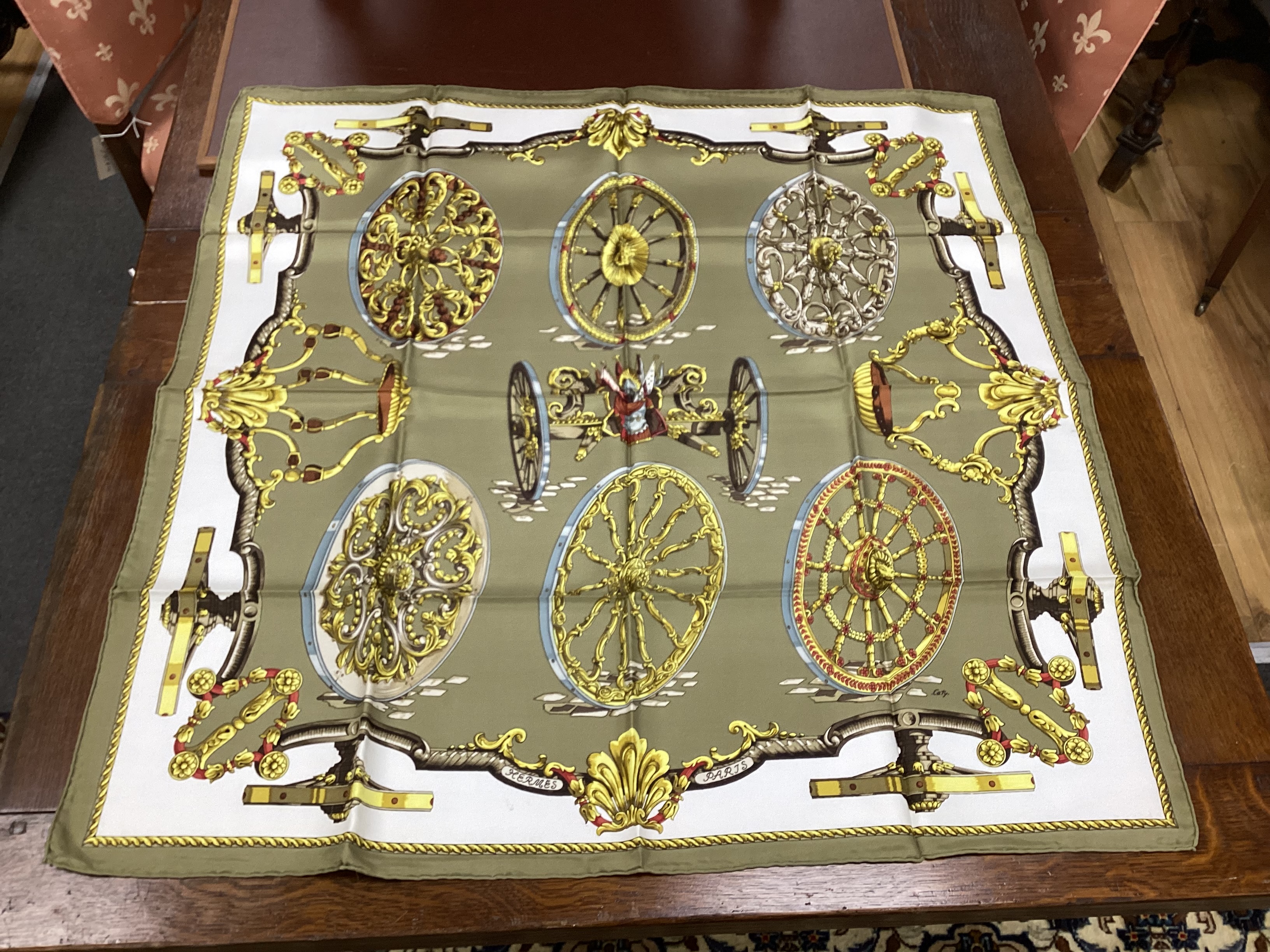Four vintage Hermes silk scarves including one retailed by Harrods comprising, Selles A Housse, Roues de Canon, Passementerie and a rectangular Brides de Gala example